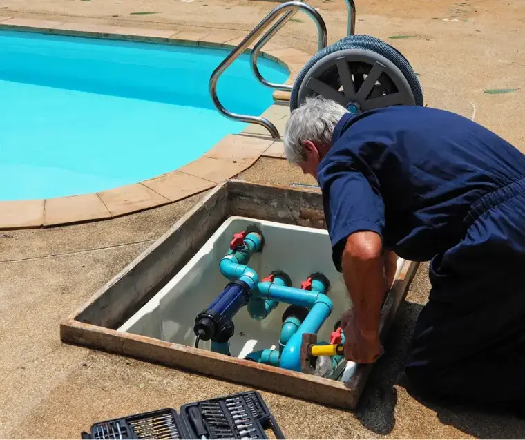 Pool equipment pad plumbing opened beside a backyard pool during a leak check in Woodland Hills