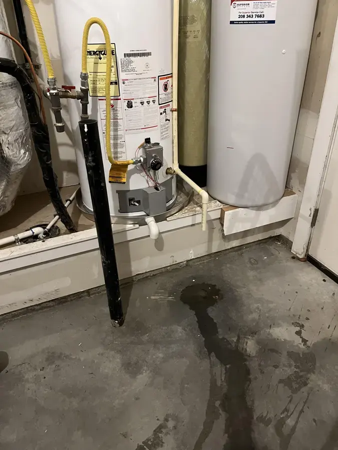 Water spreading across a garage floor from a leaking water heater